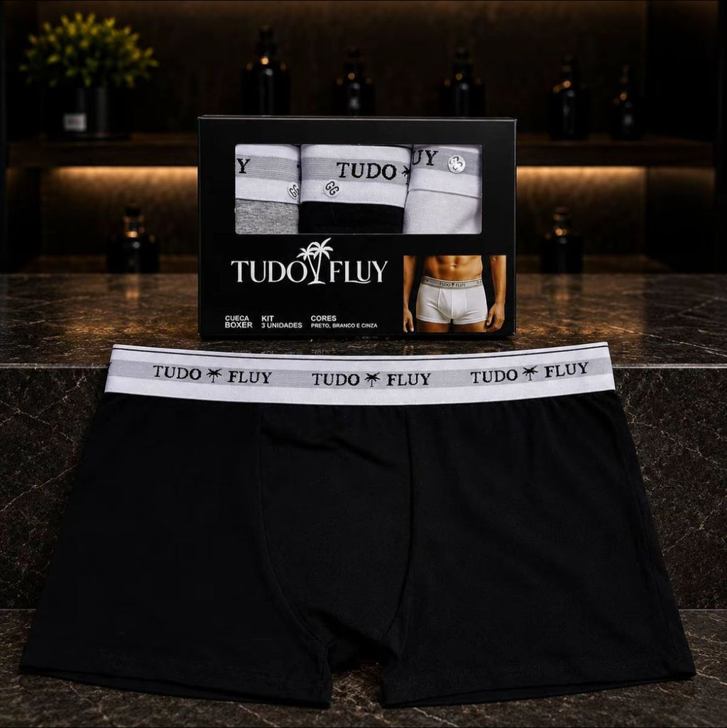 Cueca boxer masculina preta Tudo Fluy ao lado da caixa do kit