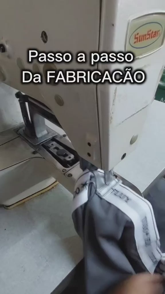 Costura das cuecas boxer na fábrica: máquina industrial fechando o cós elástico